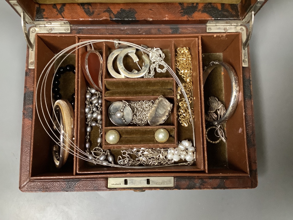 A small leather jewellery box containing assorted silver and other jewellery.